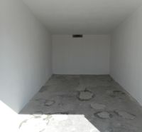 Parking garage in Trenčín on Ľudovíta Stárka with a concrete floor and white walls.