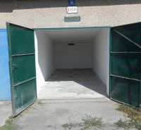 Open garages on Ľudovíta Stárka Street in Trenčín with concrete floors and green doors.