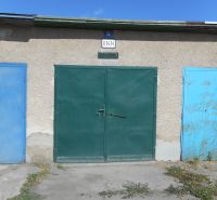 Garages on Ľudovíta Stárka Street in Trenčín with colorful doors and a cement surface.
