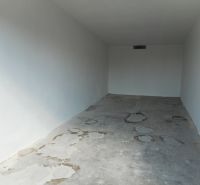 An empty space with white walls and a concrete floor. Garages in Trenčín on Ľudovíta Stárka.