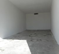 A view into an empty space with a concrete floor in a garage.