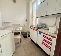 Kitchen area in the production premises with tiles and storage cabinets.