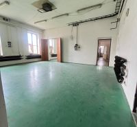 Production facilities with green flooring and white walls with lighting.