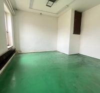 The interior of a manufacturing space with white walls and a green floor.