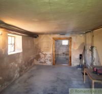 The basement of a family house in Ružiná with a concrete floor and simple furniture.