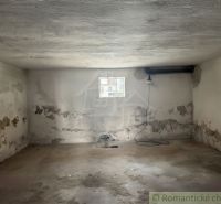 A room in a family house with old plaster and a smaller window.