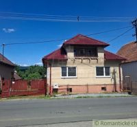 A family house in Ružiná, with a red-brown roof and a garden behind the fence.