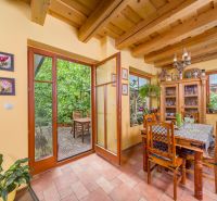 Dining in a family house with a table, plants, and a view of the terrace.