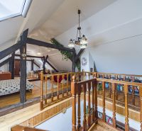 The attic of a family house with wooden railings, beams, and flooring with a wooden decor.