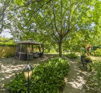 The garden of a family house on Čigérska Street in Dunajská Streda, gazebo, trees, floral decorations.