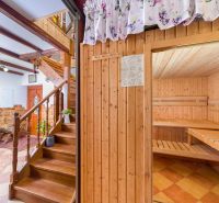 Interior of a family house with a staircase, wooden decor flooring, and a sauna.