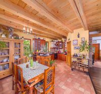 A kitchen and dining room in a family house with wooden ceilings and a floor with a wooden decor.