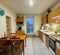A kitchen in a family house with wooden decor furniture and a dining table.