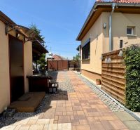 Paving in the courtyard of a family house in Čakajovce with wooden elements and greenery.