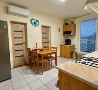 A kitchen in a family house with a dining area, a gas stove, and built-in appliances.