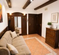 A comfortable hallway in a 2-room apartment with a mirror, sofa, and wooden furniture.