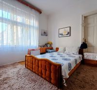 Bedroom in a 4-room apartment with a carpet, an orange bed, and a large window.