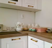 A kitchen unit with wood decor and a vintage tea set in a 4-room apartment.