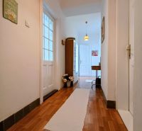 A hallway with light walls, a white carpet, and a floor with a wooden decor in a 4-room apartment.