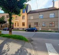 Daniel Dlabač Street in Žilina with an apartment next to the road and trees.