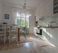 The kitchen of a 4-room apartment with white cabinets and a dining table, floor with wood decor.
