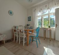Dining area with a table and chairs in a 4-room apartment, floor with wooden decor.