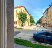 Daniel Dlabač Street in Žilina with a view of a 4-room apartment through the window.