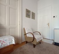 Interior of a 4-room apartment with an armchair, carpet, and drawings on the walls.