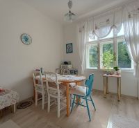 Dining room in a 4-room apartment with a wood-patterned floor and wooden furniture.