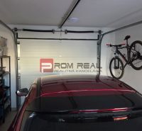 A family house garage with shelves, a bicycle, and a car.