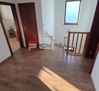 A hallway in a family house with a wooden decor floor and a staircase.
