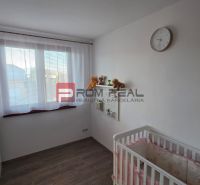 Children's room with a crib, shelf, clock, and floor with wooden decor in a family house.