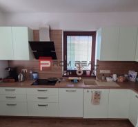 A kitchen in a family house with light cabinets and a wooden decor floor.