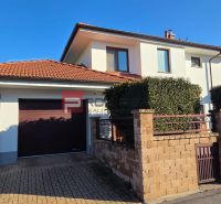 A family house on Pri Vápenickom potoku Street in Bratislava IV with a brick fence and a garage.