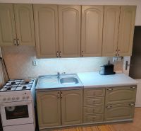 A kitchen in a 4-room apartment with a kitchen unit and a stove.