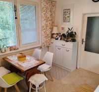 Dining area with a table and chairs, decorative curtains, and houseplants in a 4-room apartment.
