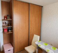 A room in a 4-room apartment with a sliding wardrobe, a chair, and an ironing board.