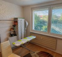 Ironing board in a four-room apartment with a wooden decor floor.