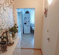 The hallway of a 4-room apartment with a decorative wall and entrance to the kitchen.