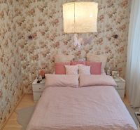 A bedroom with floral wallpaper and a wooden decor floor in a 4-room apartment.