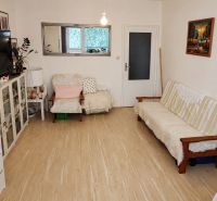 Living room with wood-patterned flooring in a 4-room apartment, bright and cozy furnishings.