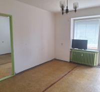A room in a 2-room apartment with a wooden decor floor and a balcony.