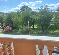 View from the balcony in Prešov on 17. novembra Street, overlooking greenery.