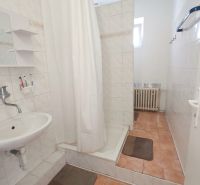 A bathroom in a family house with ceramic tiles and a shower enclosure.