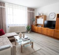 Living room with wood-decor flooring, glass table, and comfortable sofa.