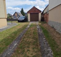 The courtyard of a family house in Lakšárska Nová Ves with a parked car and a garage.