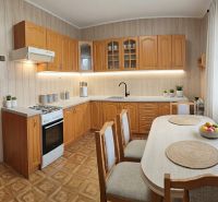 A kitchen in a family house with wooden cabinets and a floor with a wooden decor.