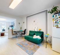 A kitchen in a 2-room apartment with decorative items and wooden floor decor.