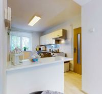 Bright kitchen with white cabinets in a 2-room apartment, floor with wood decor.