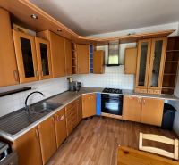 A kitchen in a 3-room apartment with a wood-patterned floor and built-in appliances.